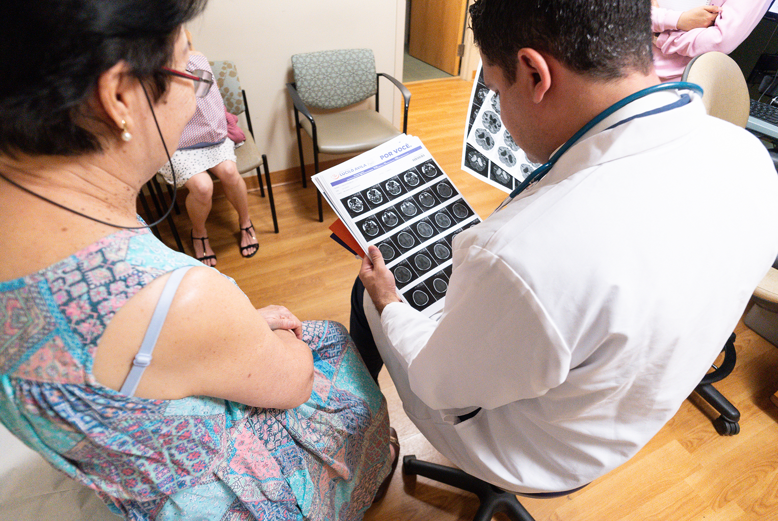 A doctor looks at medical imaging with a person.